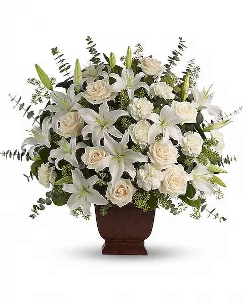 Teleflora's Loving Lilies and Roses Bouquet - A simply beautiful way to show you care. By sending this elegant arrangement to the home of those in mourning, you are letting them know they are embraced in your thoughts. And in your heart. Fresh flowers such as crème roses, white oriental lilies, carnations, eucalyptus and more are delivered in a lovely Noble Heritage urn.