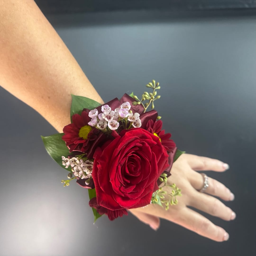 Red rose wrist corsage with small burgundy and white flowers