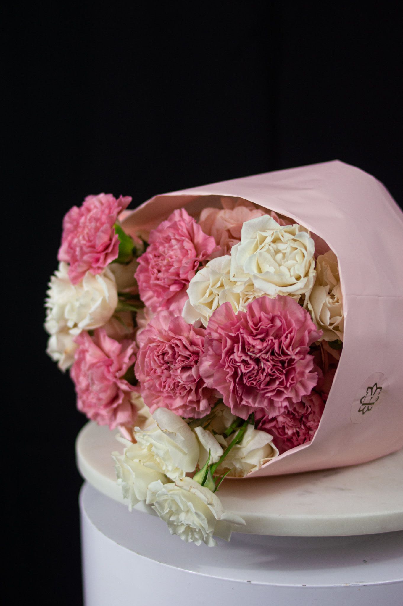 Vanilla Pink - Soft, romantic, and effortlessly elegant. Vanilla Pink is a delicate bouquet of blush and creamy ivory blooms, where ruffled carnations and garden-style roses come together in a gentle, cloud-like composition. Its muted tones and plush textures create a sense of calm, warmth, and quiet affection.  Wrapped in soft pink paper, Vanilla Pink is perfect for tender moments, heartfelt gestures, or simply celebrating love in its most graceful form.  A bouquet as comforting and sweet as its name.   Disclaimer: Due to the seasonal nature of flowers, we select the freshest blooms available. Flower varieties may vary, but we always strive to preserve the color palette, style, and overall aesthetic shown.