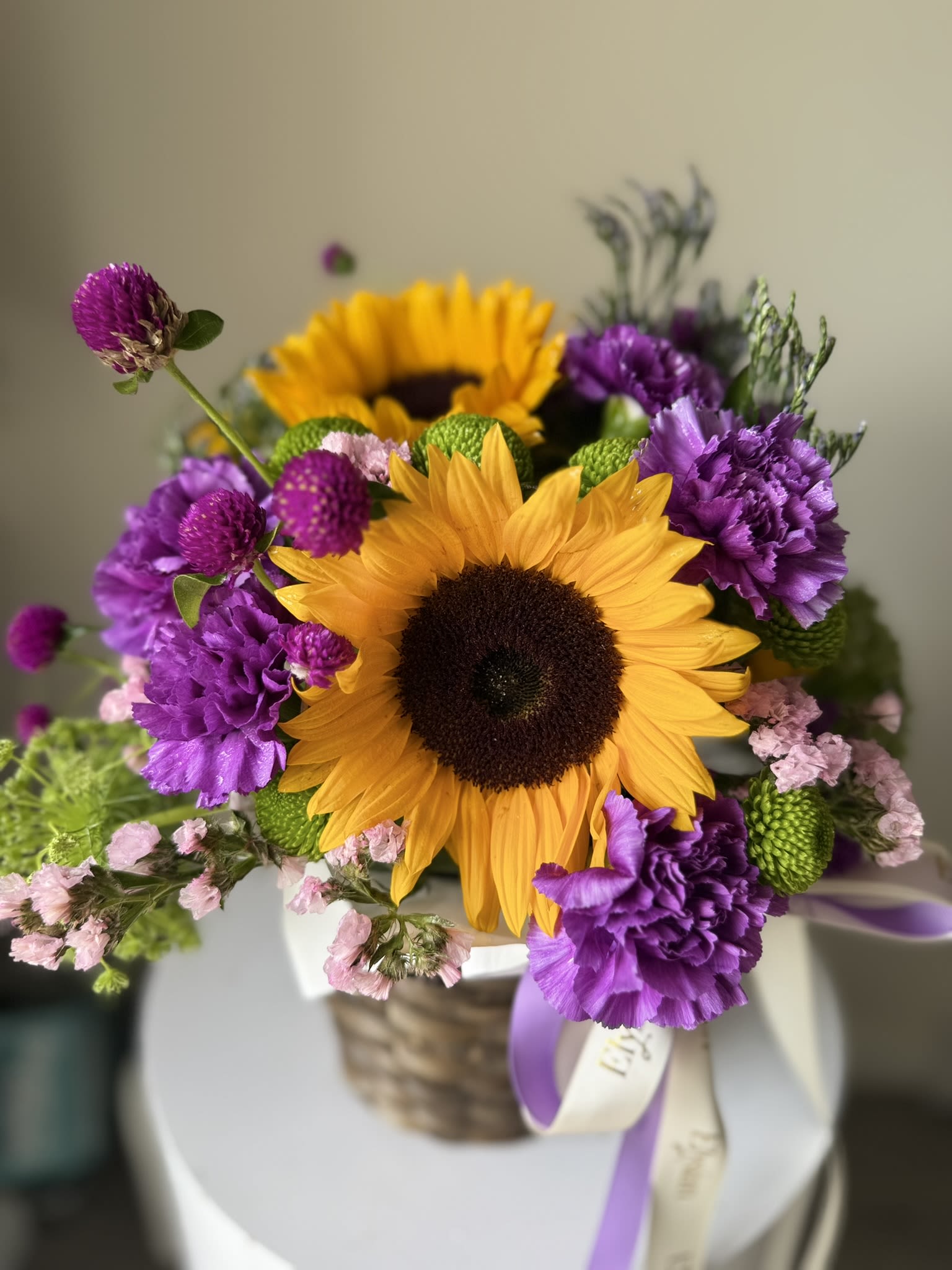 Sunflower Basket - Discover the ideal floral gift with our vibrant basket arrangement, which features a harmonious blend of sunflowers, carnations, and various fillers. Handcrafted with care, this colorful arrangement is designed to brighten any occasion. Whether it's a birthday, anniversary, or simply a thoughtful gesture, our flower box is sure to impress and bring joy.