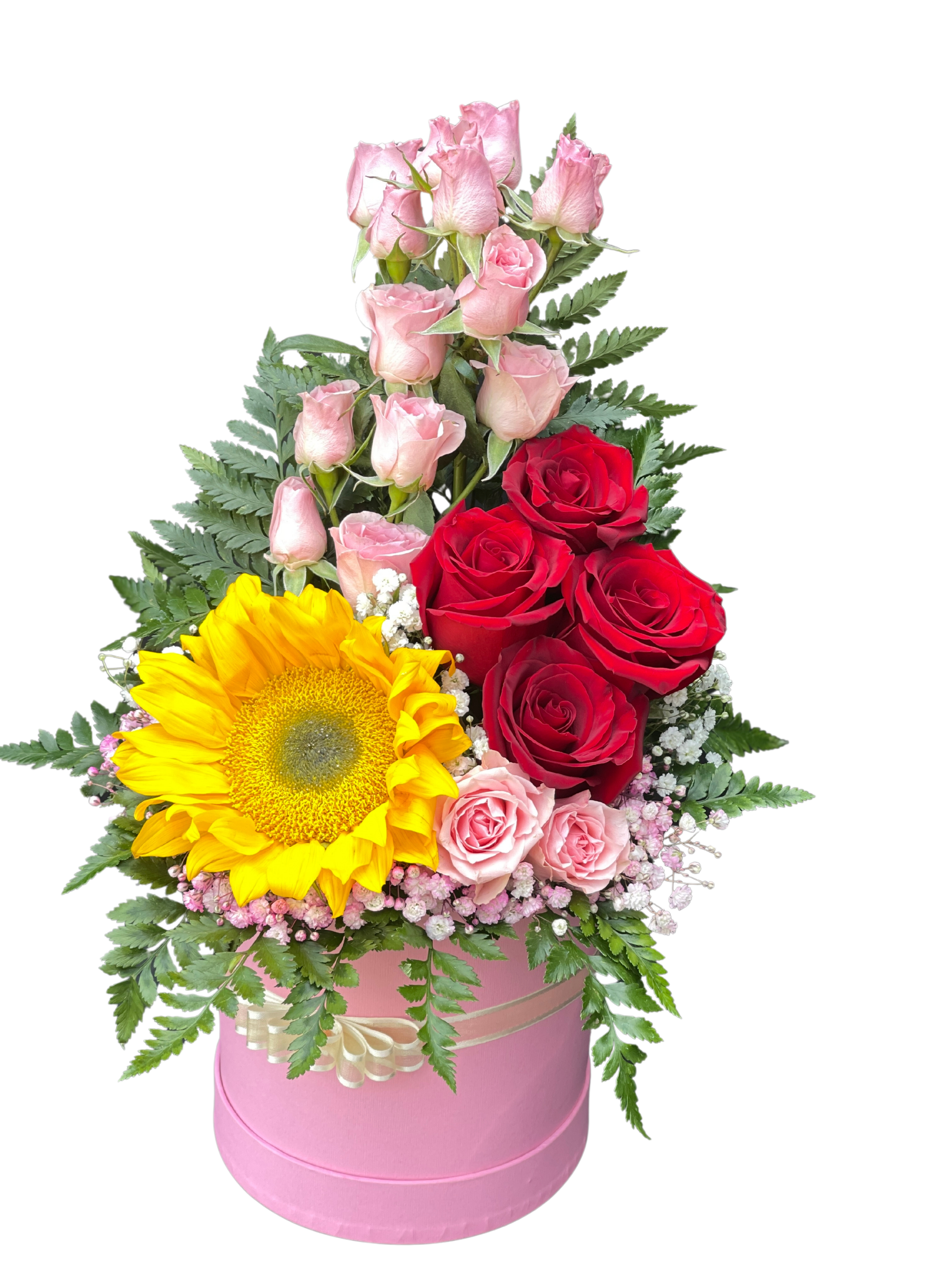 Mini Rose - A lively mix of pale pink spray roses, deep red roses, and a sunny yellow sunflower gives this mini rose arrangement a joyful, romantic eye-catcher-perfect as a birthday bouquet, anniversary gift, or cheerful congratulations arrangement. The combination of bold red, soft pink, and bright yellow reads both celebratory and intimate, so the person you're sending it to will feel noticed and warmly celebrated.  Tightly arranged in a pink round hatbox and finished with a cream ribbon, the design pairs height and texture-tall spray roses and fern-like greenery-with delicate white filler blooms and airy pink baby's breath for softness. The compact presentation makes it easy to place on a desk or bedside table; the hatbox keeps stems neatly contained while looking polished and gift-ready.  This is the kind of floral gift that says "you're special" without saying a word-ideal for a close friend, partner, or coworker. No special care is needed beyond keeping the hatbox in a cool spot away from direct sun and refreshing the water as instructed with your delivery; available in a single compact size that fits small spaces beautifully.