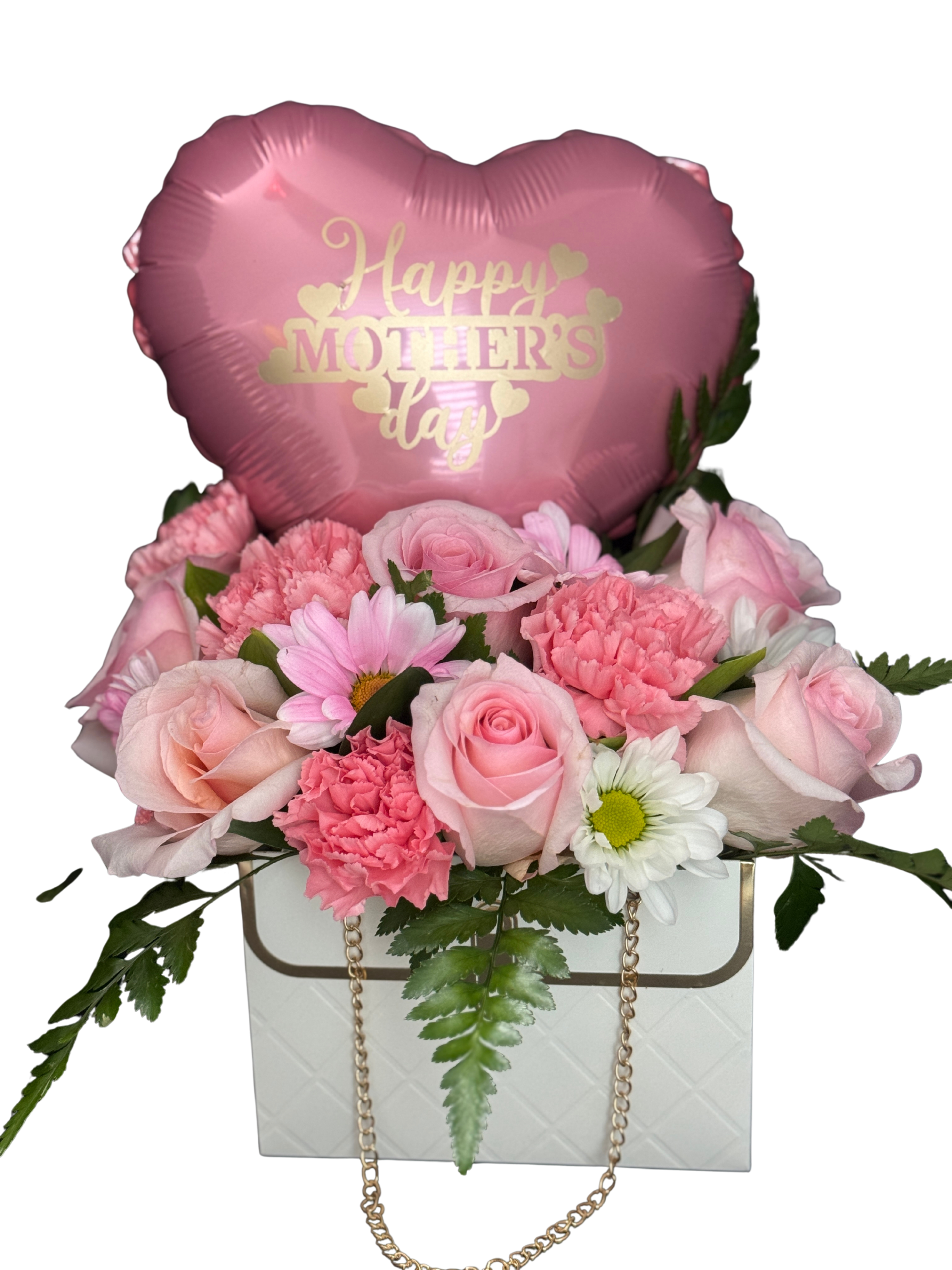 Mini bag pink  - A compact springtime surprise, this mini handbag-style flower arrangement pairs soft pink roses, blushing carnations, and petite white daisies to create a tender Mother's Day or thank-you bouquet. Designed as a gift-ready flower arrangement, the white handbag-style box with a gold chain handle and a pink heart-shaped foil balloon that reads "Happy Mother's Day" gives the recipient an instant feeling of celebration and affection.  The palette mixes blush pink, creamy white, and fresh green accents for a feminine, soothing look. Flowers are arranged tightly in the white handbag box so blooms sit beautifully at eye level and hold their shape during delivery. The heart balloon adds height and sentiment without overwhelming the compact size, making this a perfect pick for desks, small tables, or bedside greetings.  Made to make Mom-or any special woman-feel seen and loved, this is the kind of gift that says "thank you" or "I'm thinking of you" with a charming, personal touch. Order as shown for a ready-to-give presentation; light daily water refreshes to the floral foam will help keep stems fresh through the week.