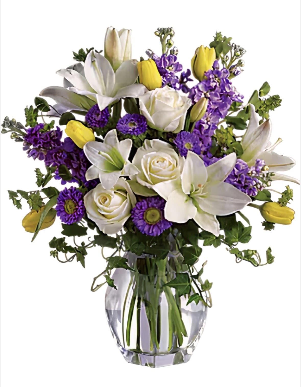 Elegant Spring Harmony - A refined and graceful floral arrangement featuring elegant white lilies, soft white roses, vibrant yellow tulips, and rich purple accents. Designed in a clear glass vase, this piece brings together freshness, balance, and sophistication—perfect for celebrating special moments or sending a touch of beauty and calm.