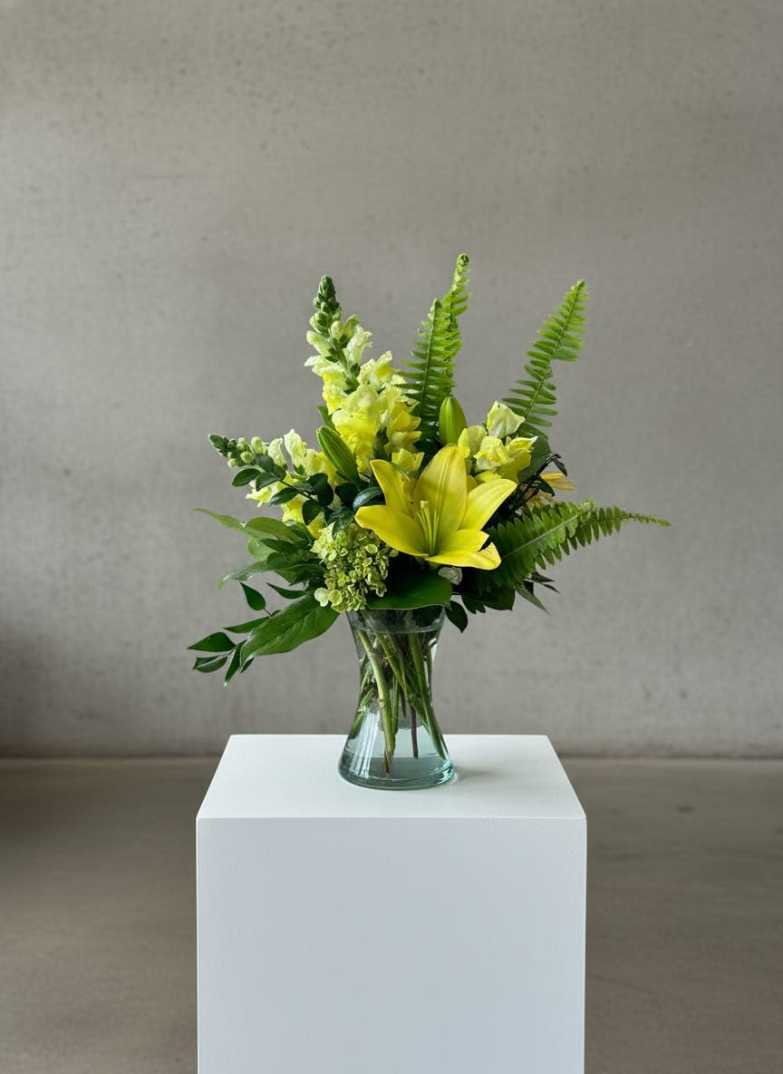 Yellow lilies and snapdragons in a clear glass vase