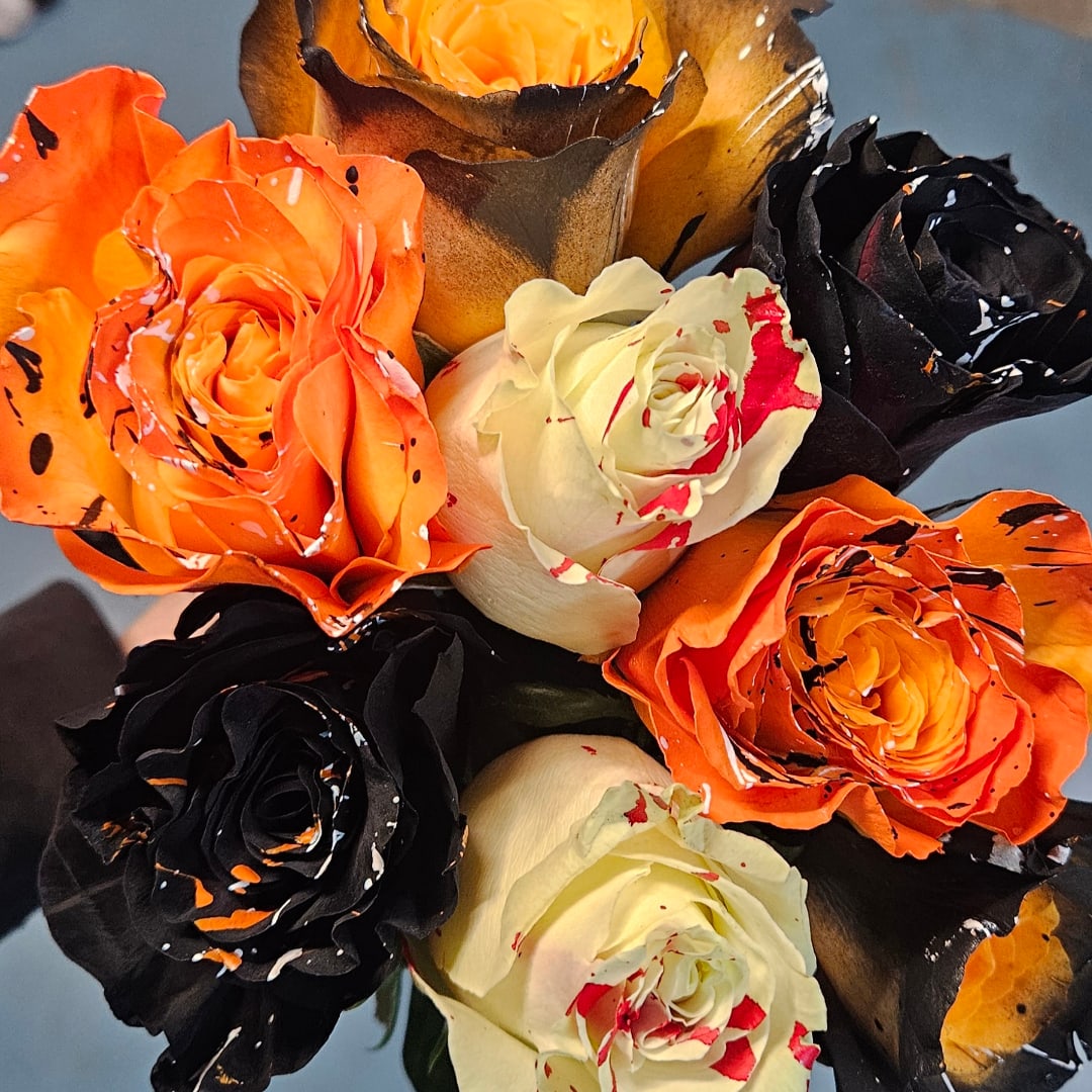 Bouquet of orange, black, and white roses with paint splatter accents