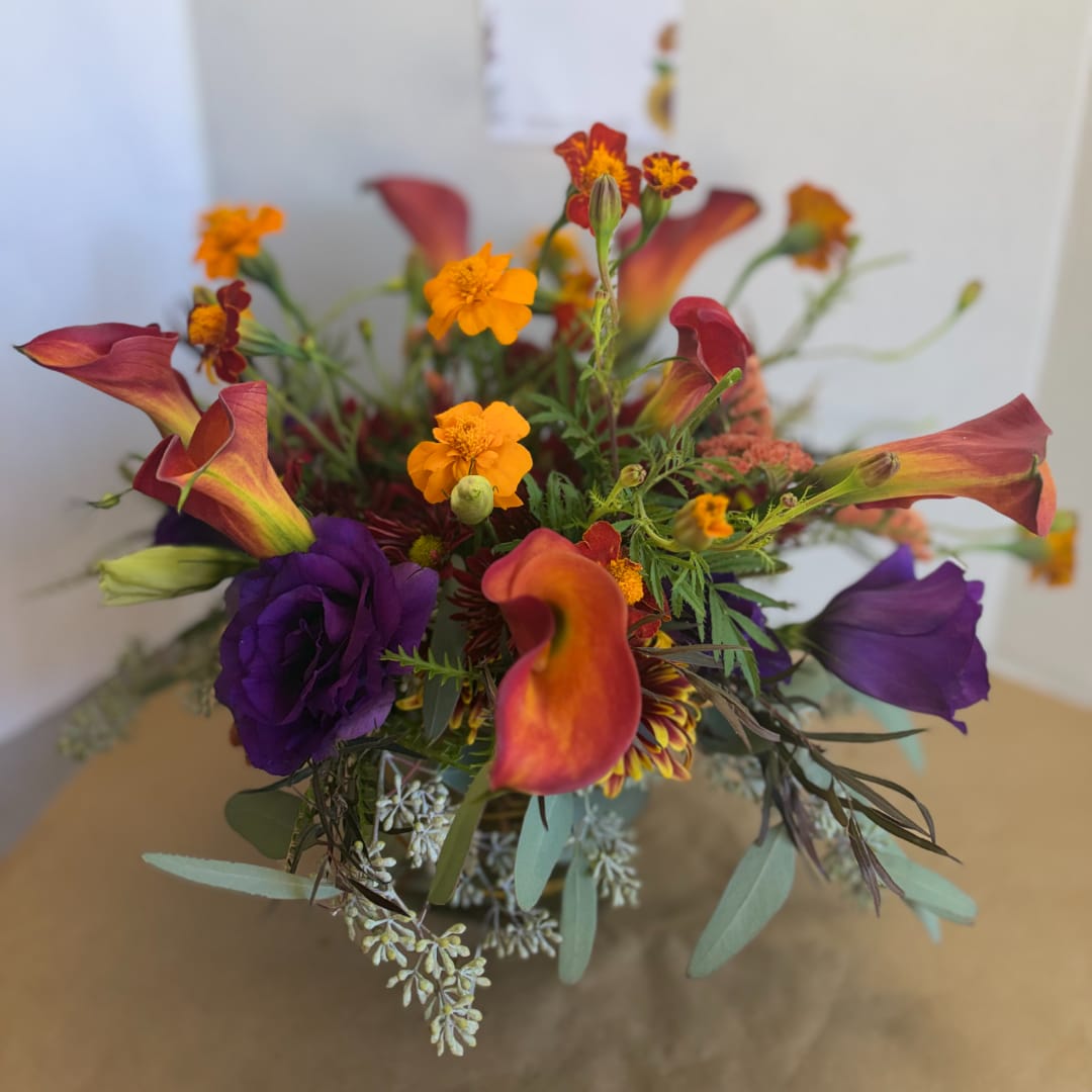 Bouquet with orange calla lilies and purple lisianthus in a vase