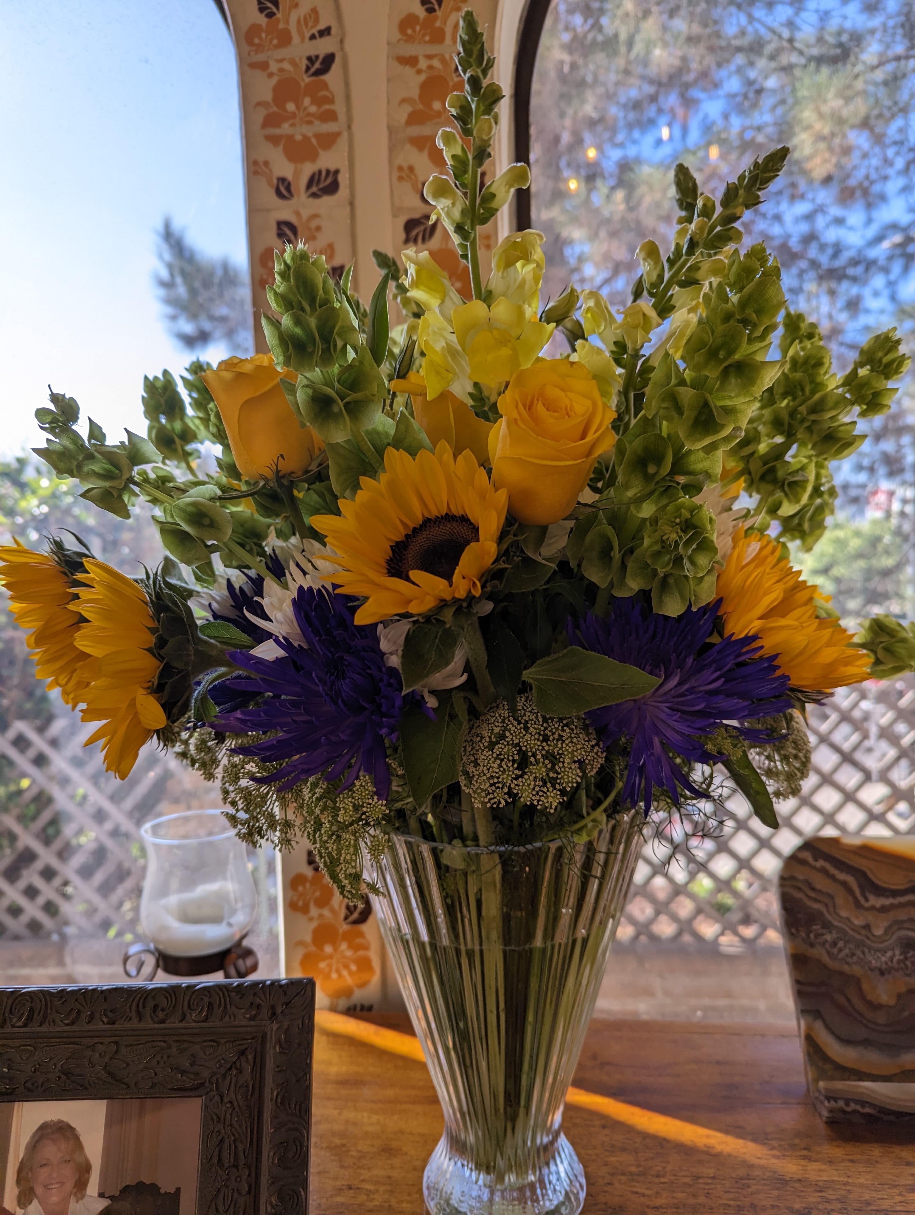 Sunshine bouquet - Yellow roses with sunflowers, purple mums, snapdragons and a variety of greenery.