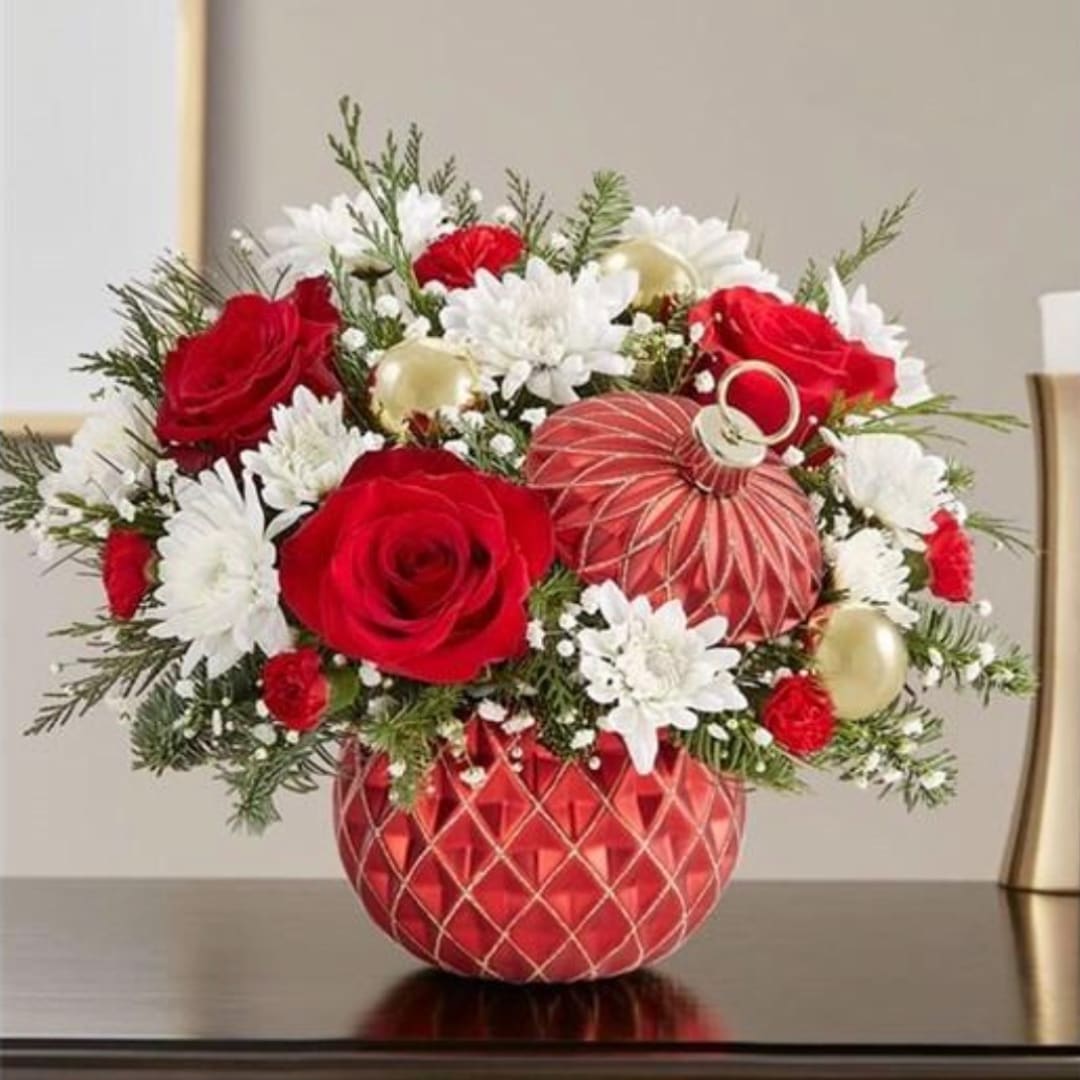 Red roses and white daisies in a red patterned vase with gold ornaments