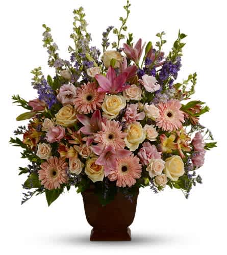 Teleflora's Loving Grace - A warm and peaceful bounty of pastel blossoms gently expresses love and respect. A gracefully composed arrangement appropriate for home or service. Fresh flowers such as peach and light pink roses lavender and purple larkspur pink asiatic lilies alstroemeria gerberas and lisianthus are set in an exclusive Noble Heritage urn.Approximately 26" W x 30" H Orientation: One-Sided As Shown : T220-1A
