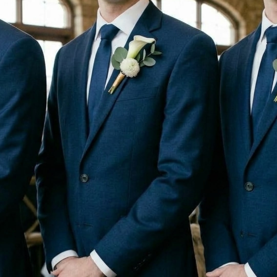 White calla lily boutonniere on a navy suit jacket