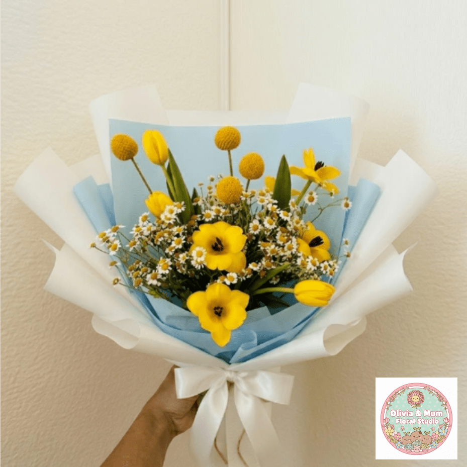 Sunnyside Up - Bright, cheerful, and full of energy—Sunnyside Up is a literal celebration in a wrap. This high-energy arrangement uses yellow tulips and playful billy buttons to bring the joy of a sunny morning directly to their door.  This seasonal bouquet features:  Yellow Tulips  Yellow Billy Buttons  Petite White Feverfew  Garden Greens