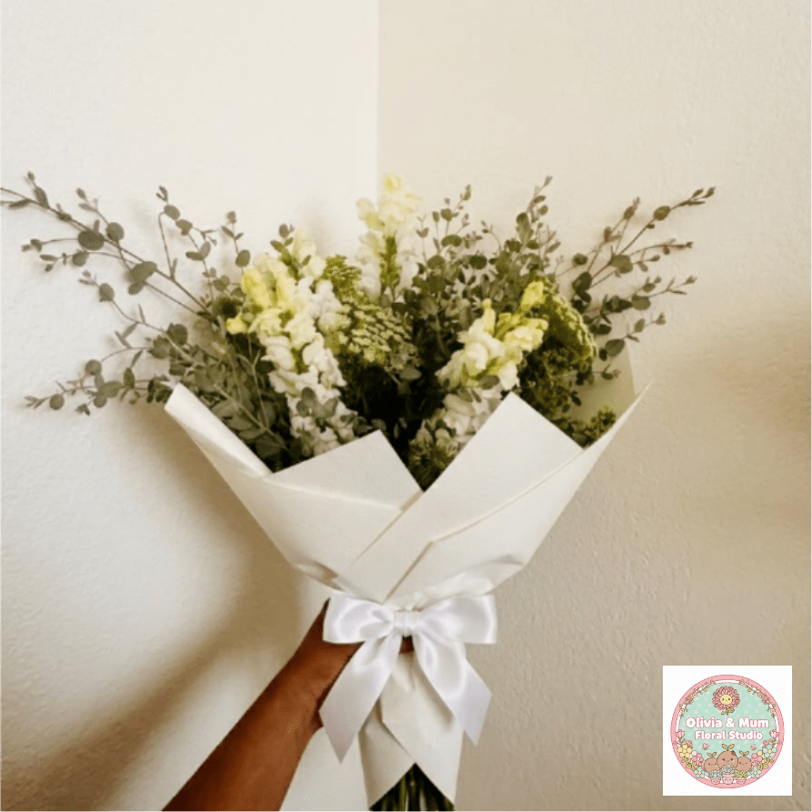 Eternal Grace - Sophisticated, soothing, and light—Eternal Grace focuses on the delicate beauty of the natural world. Airy Queen Anne’s Lace and snapdragons are paired with fragrant eucalyptus for a tribute that feels deeply peaceful.  This seasonal bouquet features:  White Snapdragons  Queen Anne’s Lace  Silvery Gunni Eucalyptus  Garden Greens  Presentation: Expertly wrapped in our signature textured paper and tied with satin ribbon. Prefer a vase? Add one to your cart to complete the look.  Personal Touch: We’ll include a custom card message with every order. You’ll be able to write your message at checkout.  Please Note: All flowers are subject to seasonal availability. If a specific bloom isn’t available, our designers will thoughtfully substitute with flowers in a similar shape, style, and color.  Standard size shown. Vase upgrade is optional.   Floral Care Guide  Your arrangement arrives in our signature "double wrap" and is nestled in a protective box. While the stems are secured with a wet wrap for transit they are ready for a full drink!   Unpack: Gently lift the bouquet from the box. Remove the plastic bag and wet towel from the stems. Trim &amp; Hydrate: Trim 1/2" off stems at an angle and place in a clean vase with cool water. Refreshed: Change water daily for a long-lasting bloom.  