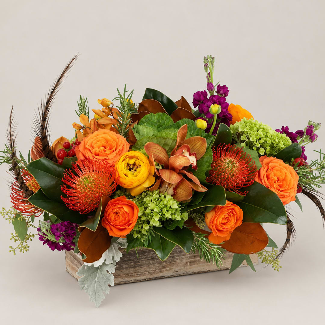 Orange and purple floral arrangement in a rustic wooden box