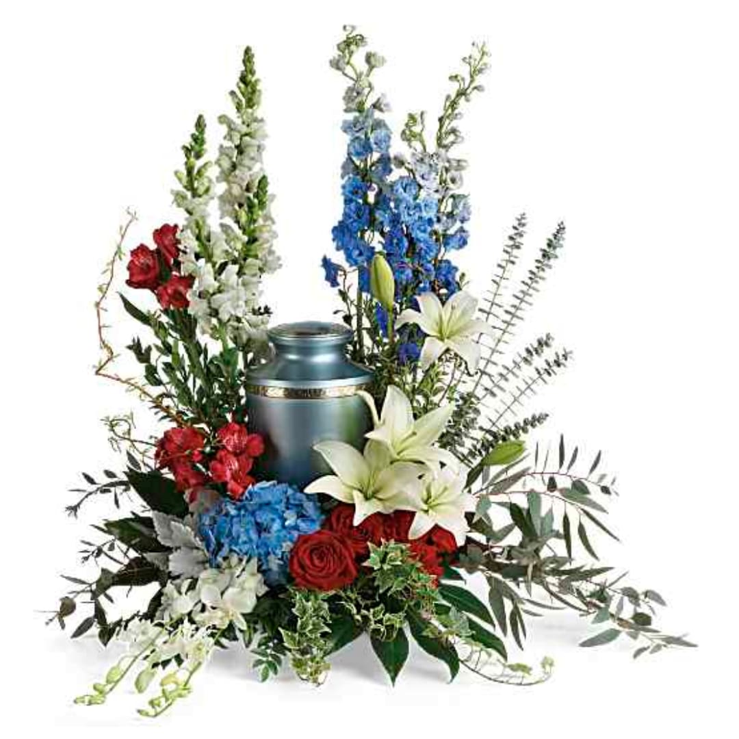 Floral arrangement with red, blue, and white flowers around a blue urn