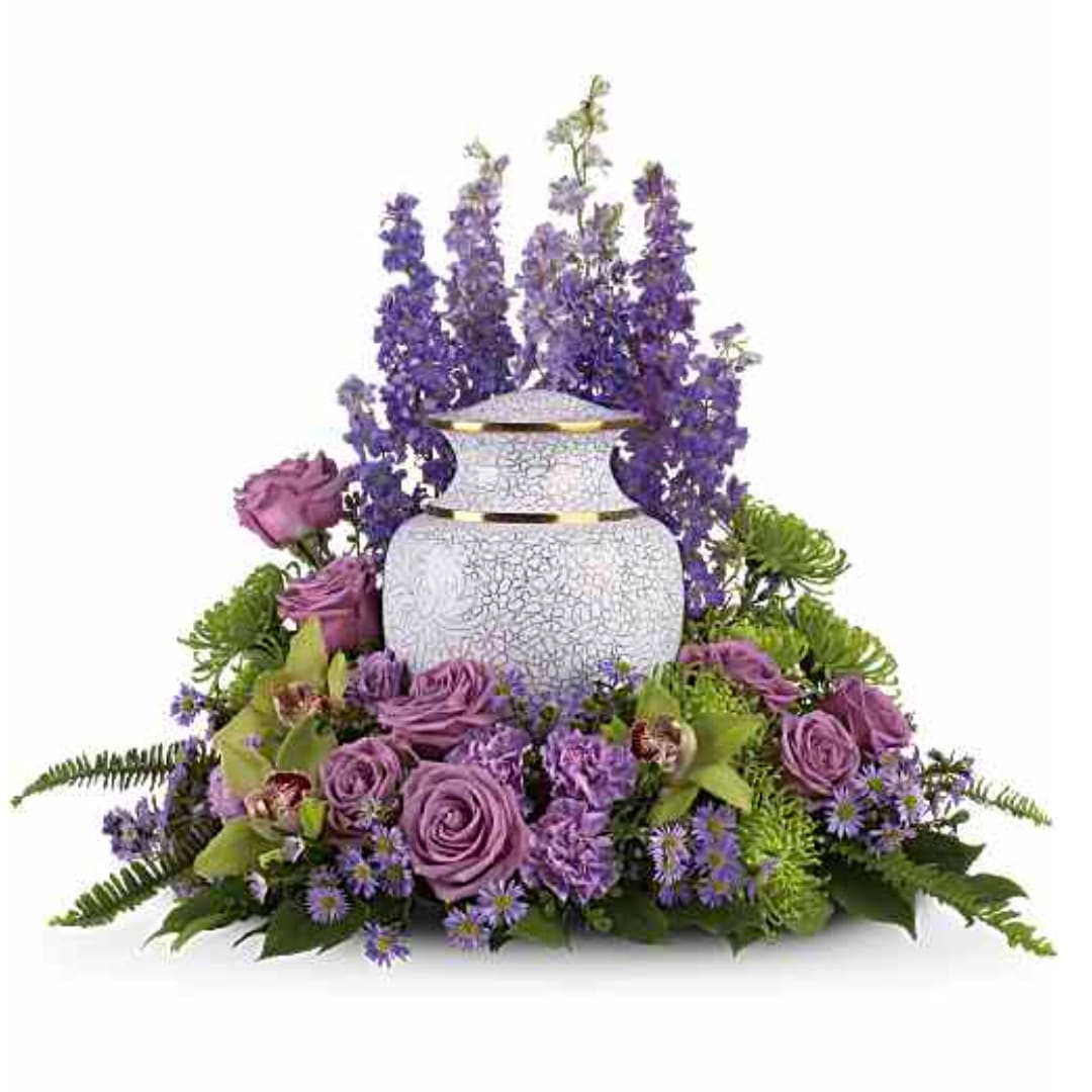 Purple floral arrangement around a white urn vase