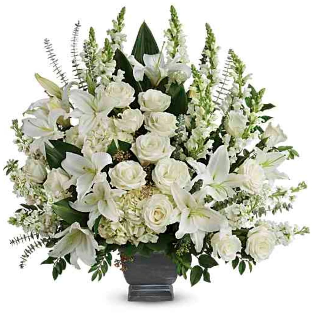 White roses and lilies arranged in a dark vase