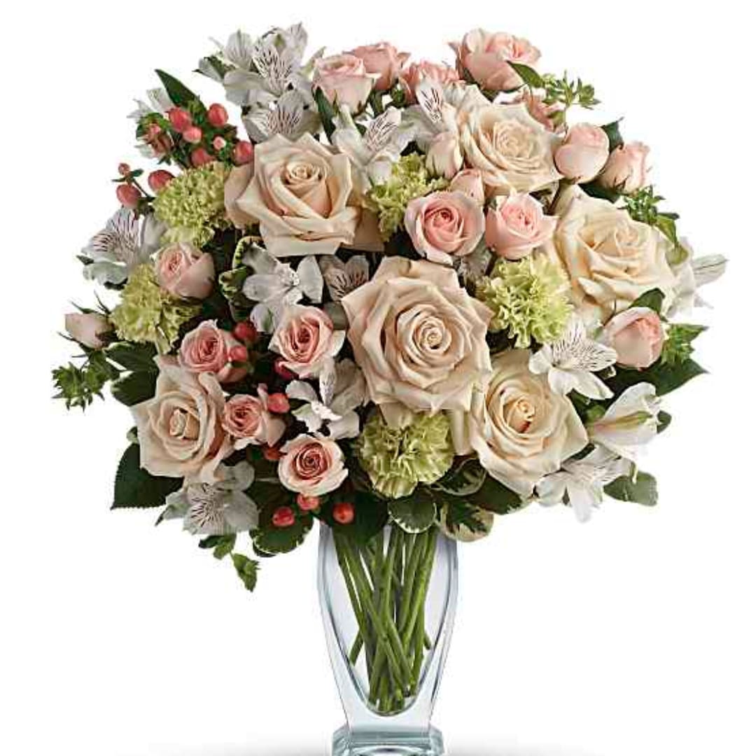 Bouquet of blush and cream roses in a clear glass vase