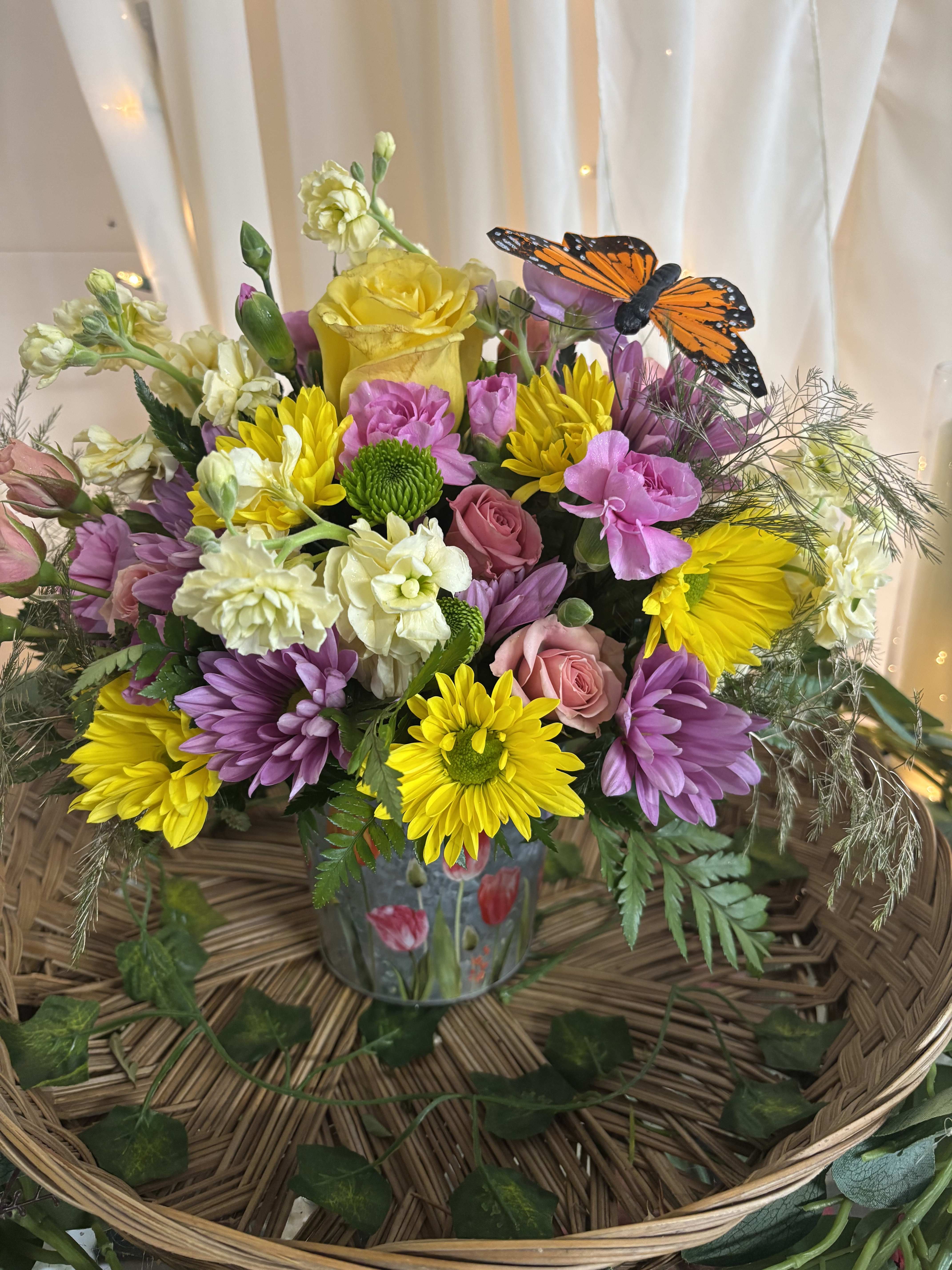 Colorful bouquet in a glass vase with a butterfly decoration