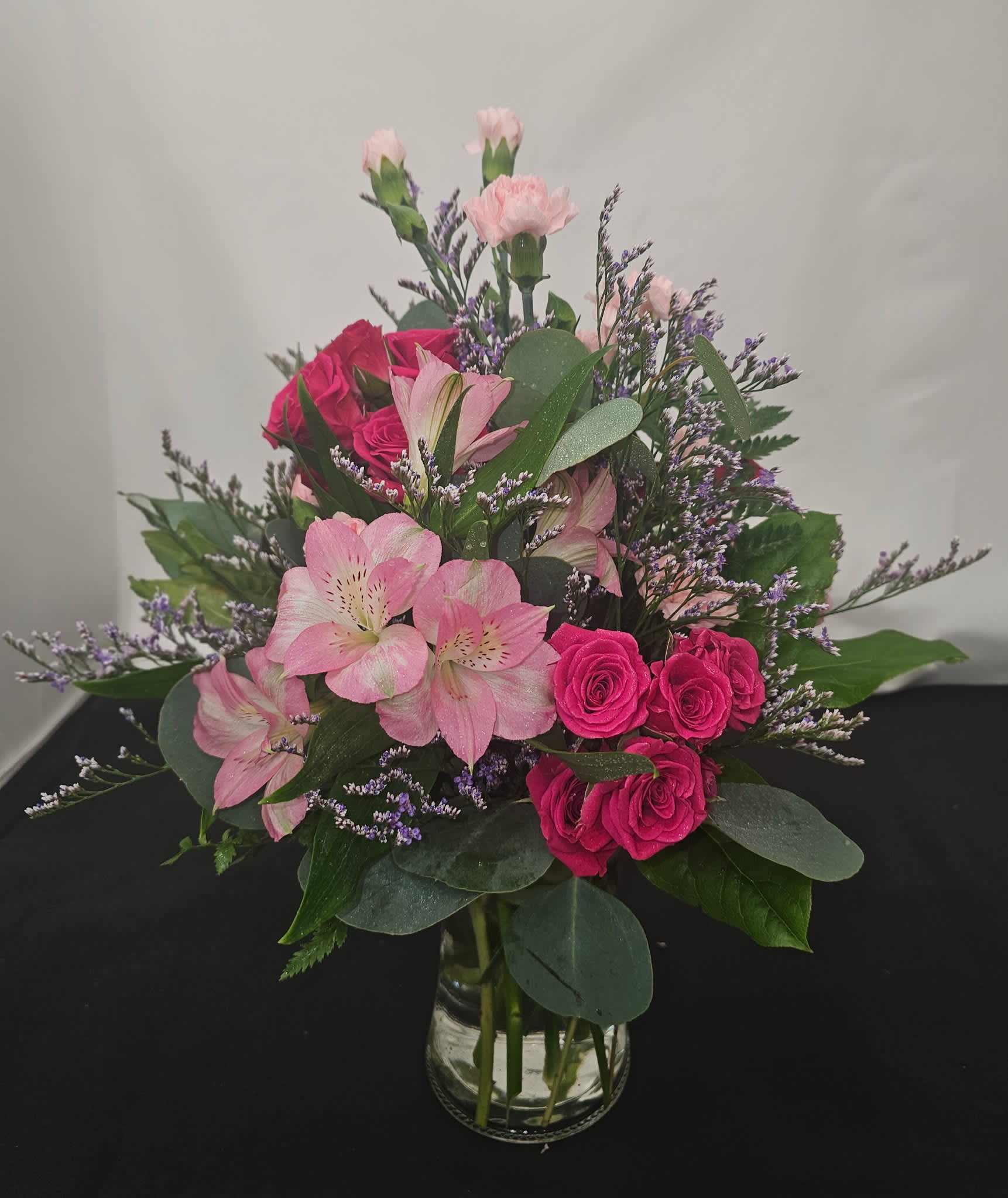 Pink roses and alstroemeria in a clear glass vase