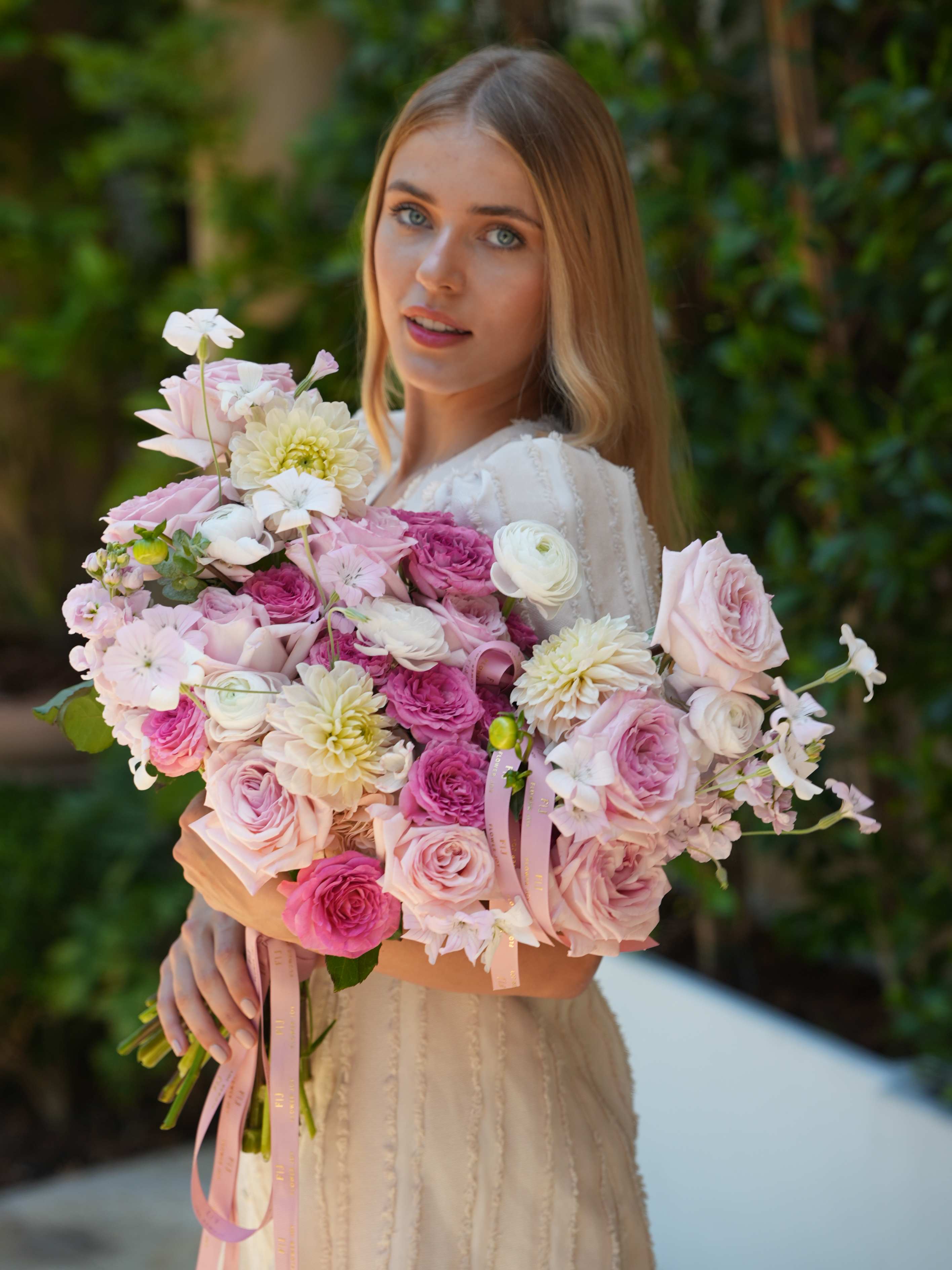Woman holding a large bouquet of pink and white flowers