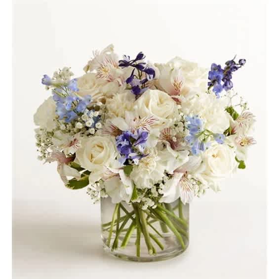 White and blue mixed bouquet in a clear glass vase