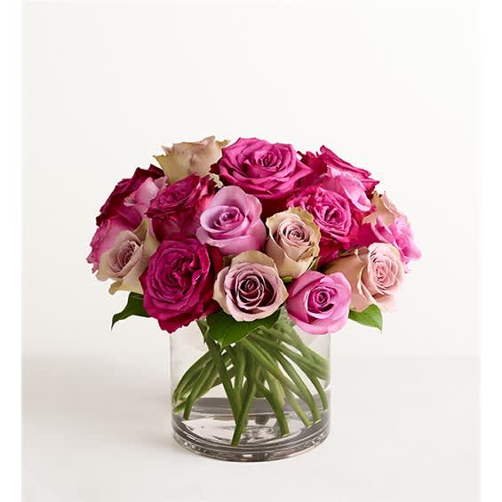 Bouquet of pink and magenta roses in a clear glass vase