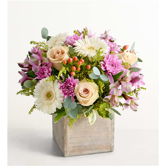 Pink and cream mixed flowers in a wooden cube vase