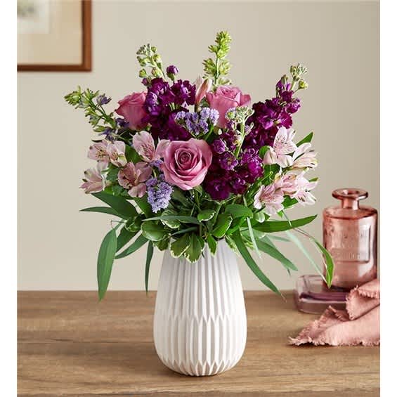 Pink and purple flower arrangement in a white vase