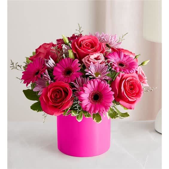 Pink roses and gerbera daisies arranged in a bright pink box