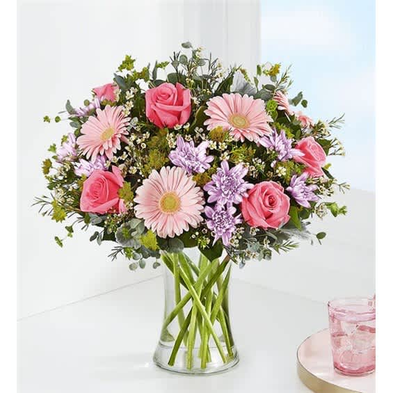 Pink roses and gerbera daisies in a clear glass vase