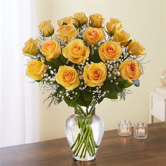 Yellow roses arranged in a clear glass vase with baby's breath
