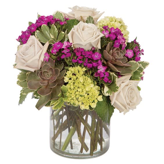 Bouquet of white roses, magenta flowers, and succulents in a clear glass vase