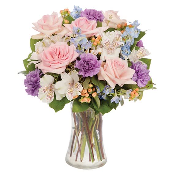 Mixed bouquet of pink and purple flowers in a clear glass vase