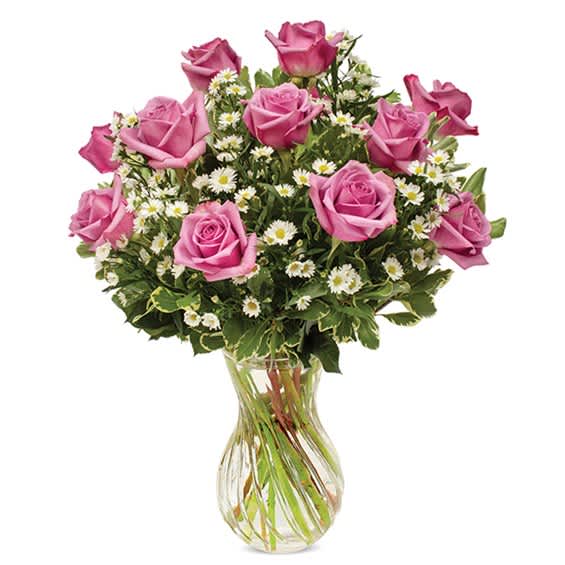 Pink roses and white daisies arranged in a clear glass vase