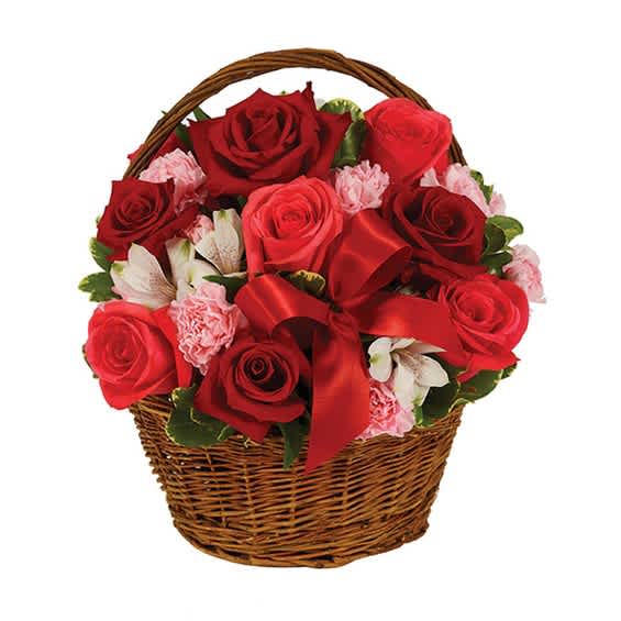Red roses and pink carnations in a wicker basket with a red ribbon