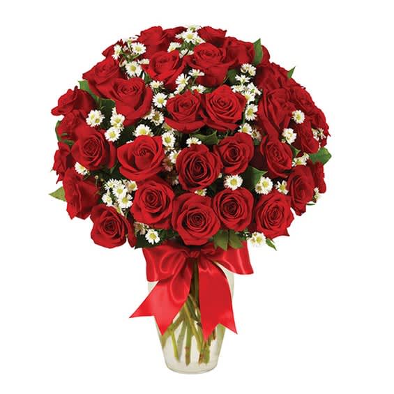 Bouquet of red roses with small white daisies in a glass vase