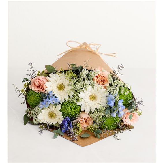 Mixed bouquet with white daisies, peach roses, and blue flowers in kraft wrap