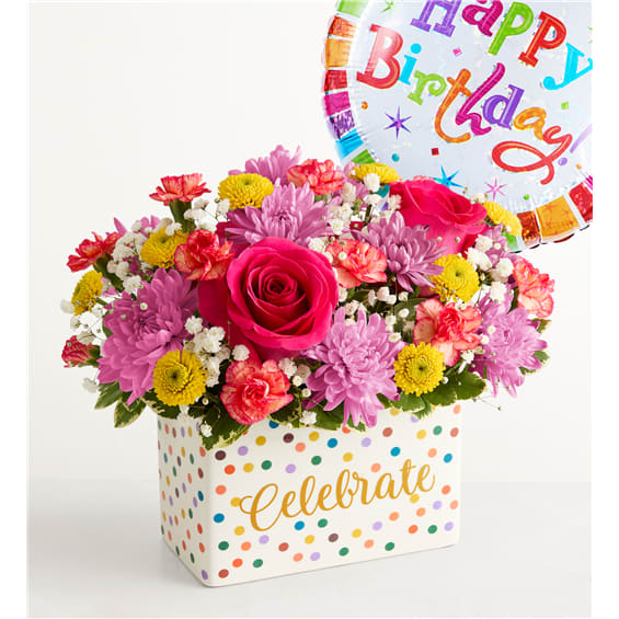 Bright mixed flower arrangement in a polka-dot gift box with a birthday balloon
