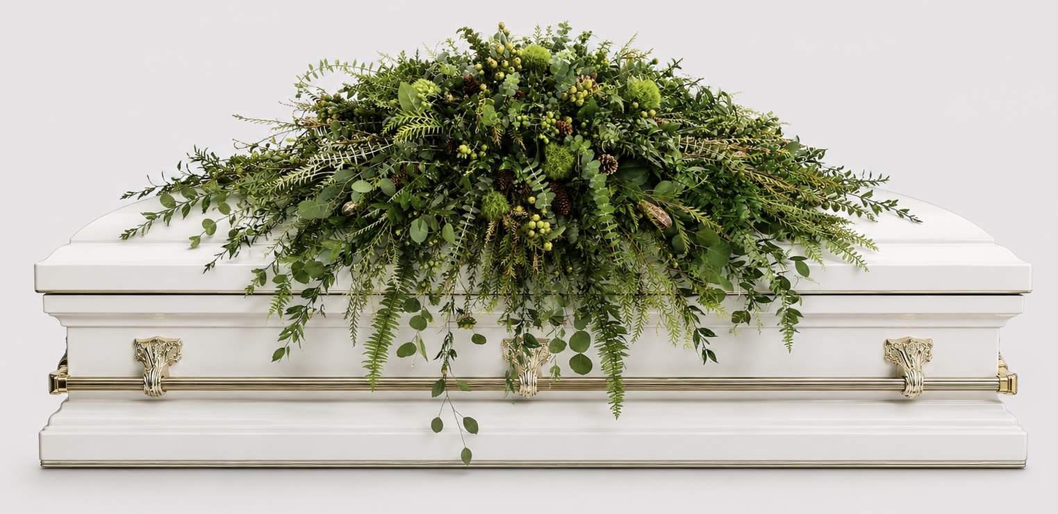 Woodland Remembrance Casket Spray - A lush cascade of mixed greenery designed for a funeral or memorial, this casket spray brings a calm, woodland grace to a white casket. As a casket spray for sympathy services, it offers a natural, understated statement-the kind of tribute that lets the person you're honoring feel seen without overwhelming the service.  The arrangement features varied textures: fern-like fronds, rounded glossy leaves, and small clustered accents in green and soft yellow tones, artfully layered to create depth and movement. It is arranged to spread broadly across the top of the casket and to drape softly over the front edge, creating a formal yet organic silhouette that complements the white casket beneath.  Ideal for a family member, close friend, or colleague, this piece conveys quiet respect and a connection to nature-perfect for woodland, rustic, or traditional memorial settings. Please note this is a full casket spray sized to cover the casket top; contact us with any special requests for placement or personalization.