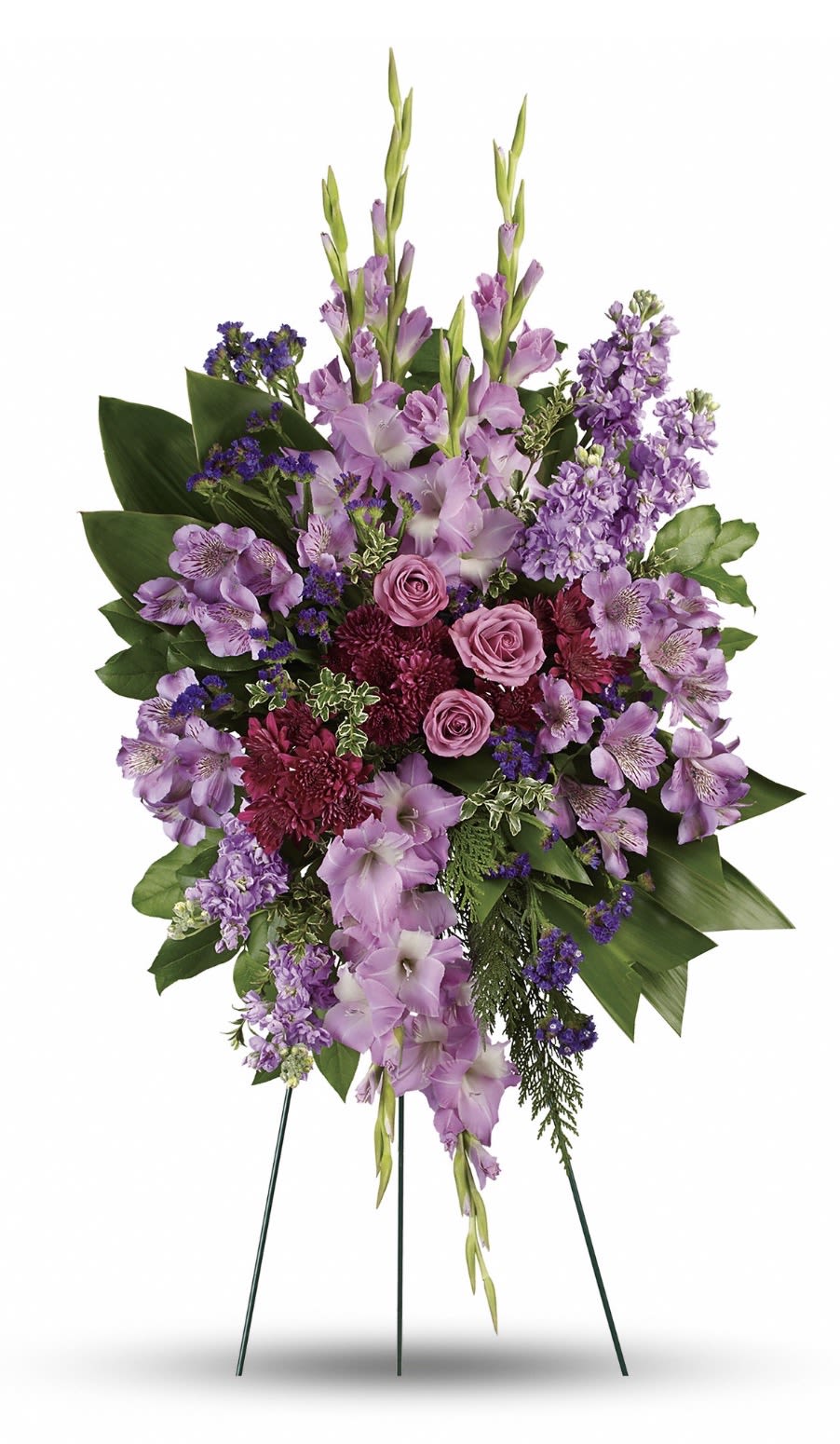 Lavender Reflections Spray - Soft lavender and deep plum blooms combine to create an elegant sympathy standing spray that reads as both peaceful and dignified. This funeral spray offers a tall, layered composition designed for memorial services - the kind of floral tribute that helps the person you're honoring feel remembered with quiet grace.  Long gladiolus spikes rise above a dense body of roses, alstroemeria, chrysanthemums, snapdragons and small purple filler flowers, with broad dark green foliage framing the piece for a formal, traditional silhouette. Colors range from pale lavender and pink to richer purples and white accents, giving the spray depth and gentle contrast. Arranged on a sturdy floral easel, it presents well beside a casket or at a memorial and holds its shape for the service.  Appropriate for sympathy, funeral, or remembrance ceremonies, this arrangement sends a thoughtful message of comfort and respect to family and friends. Sizes are tailored to typical standing-spray proportions and the sturdy easel makes delivery and placement simple; no special care is needed beyond keeping water available to the floral foam if the service is delayed.