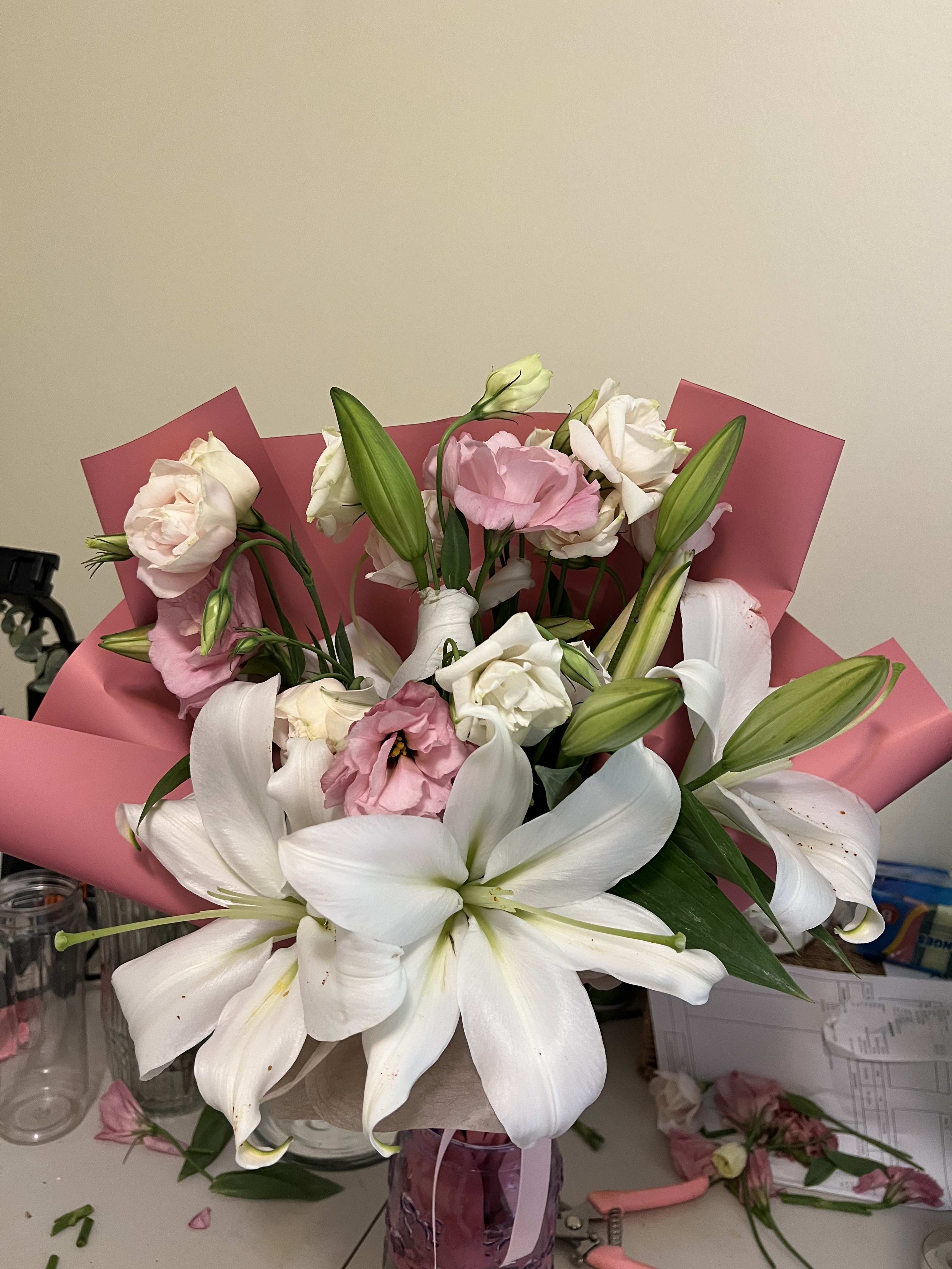 Bouquet of white lilies and pink roses wrapped in pink paper