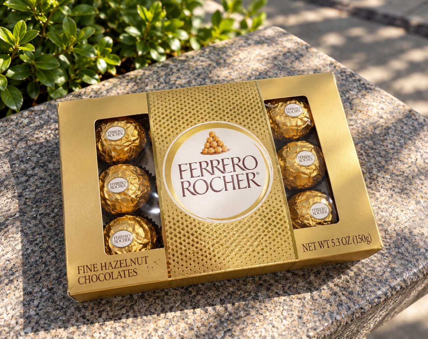 Box of Ferrero Rocher chocolates on a stone surface outdoors