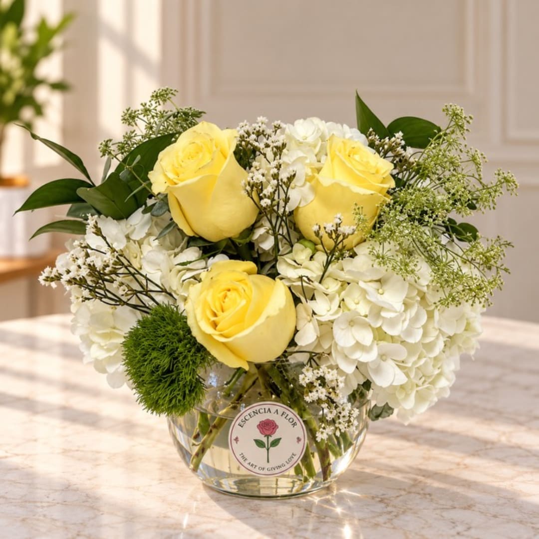 Yellow roses and white hydrangeas in a clear glass vase