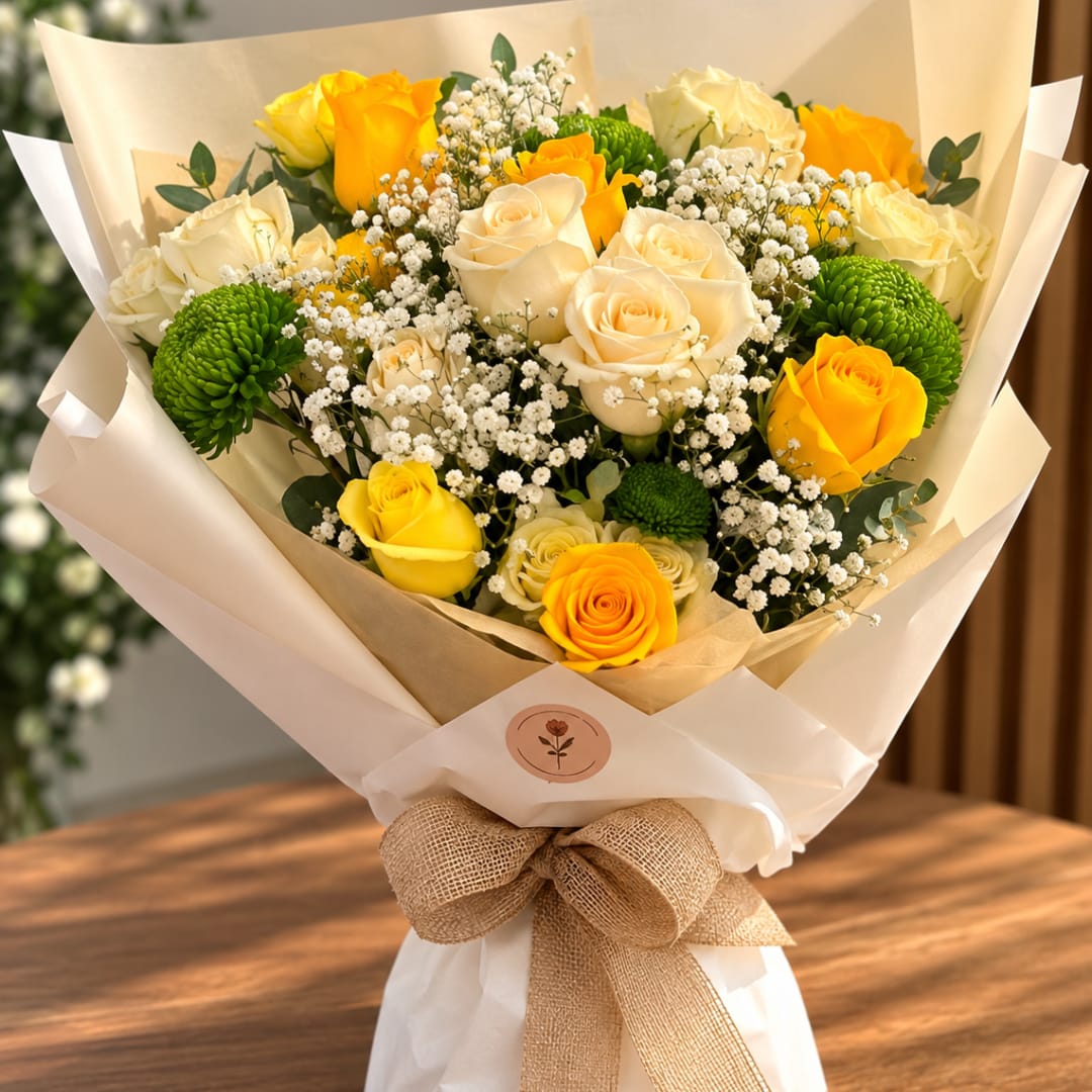 Bouquet of yellow and cream roses with white baby's breath and green button mums