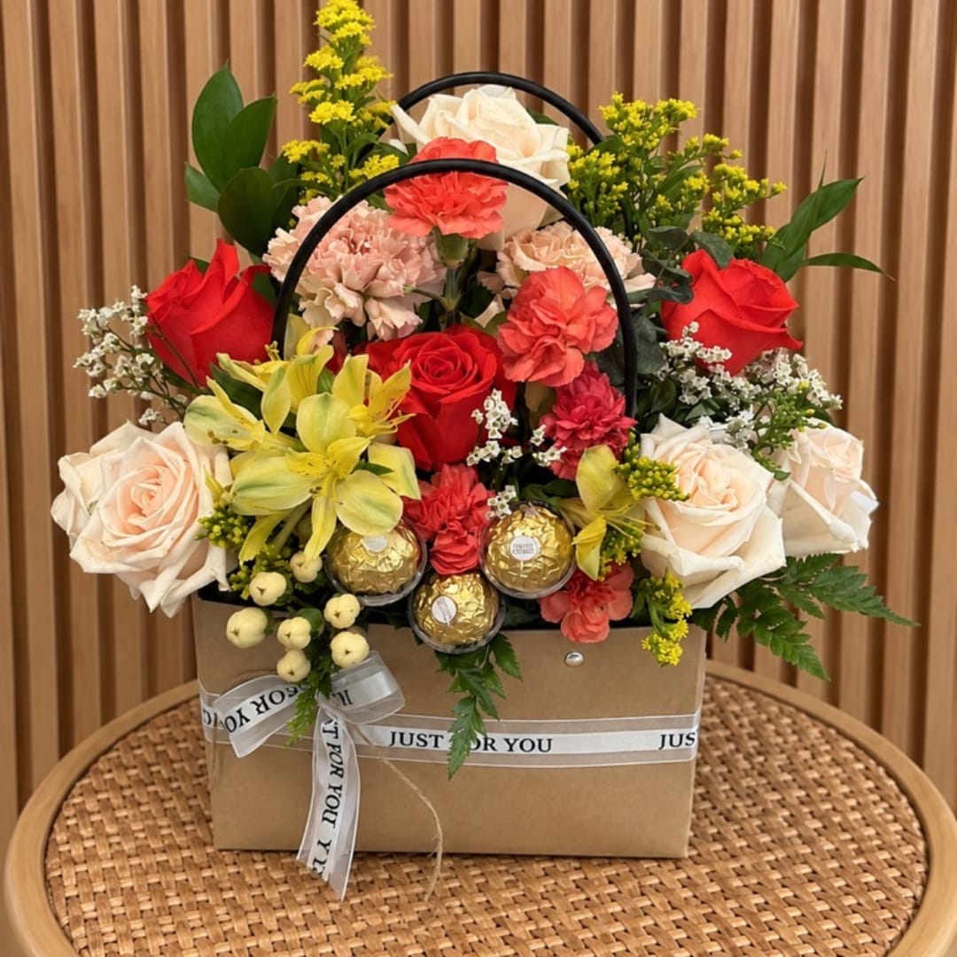 Mixed flower basket with roses, carnations, lilies, and chocolates