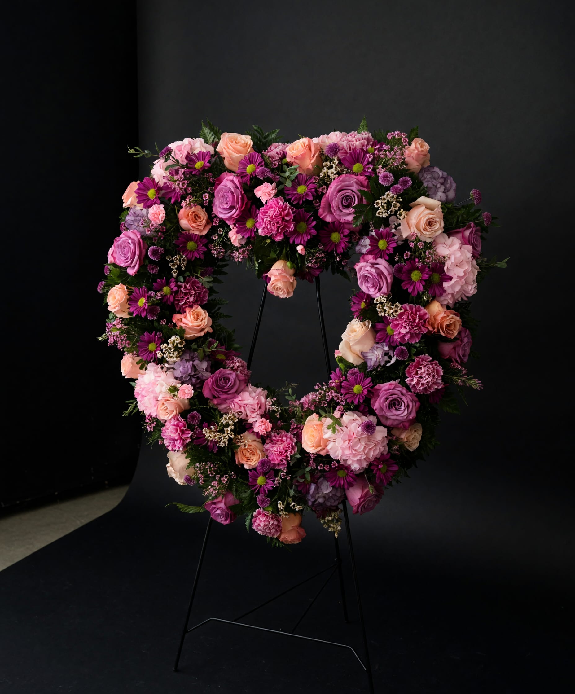 Forever in Bloom - A lush heart-shaped sympathy tribute in soft lavender, blush, and pink blooms, designed to honor a cherished life with beauty and love.