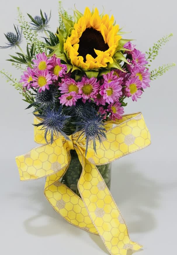 Sunflower bouquet with pink daisies and blue thistle, tied with a yellow ribbon