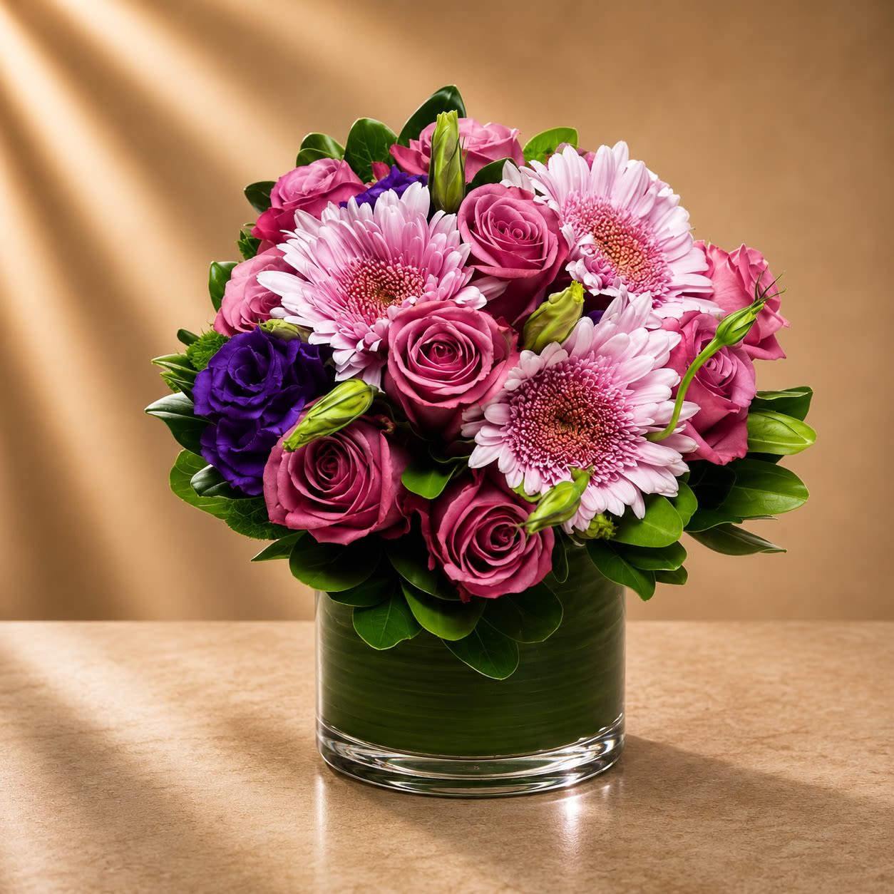 Mauve Élan - Elegant, romantic, and fashion-forward, Mauve Élan is a luxurious floral arrangement designed with velvety mauve roses, blush gerbera daisies, rich violet lisianthus, and lush emerald foliage in a sophisticated contemporary style.  The soft mauve palette paired with deep violet accents creates a refined balance of romance and modern elegance. Layered textures and vibrant blooms give the arrangement movement and couture-inspired beauty, making it both graceful and striking.