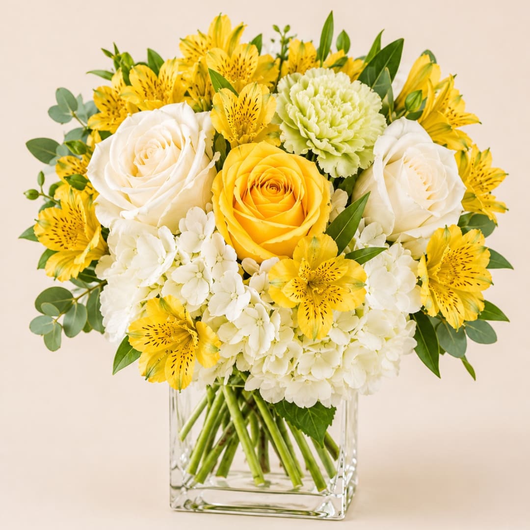 Bouquet of yellow and white flowers in a clear glass vase