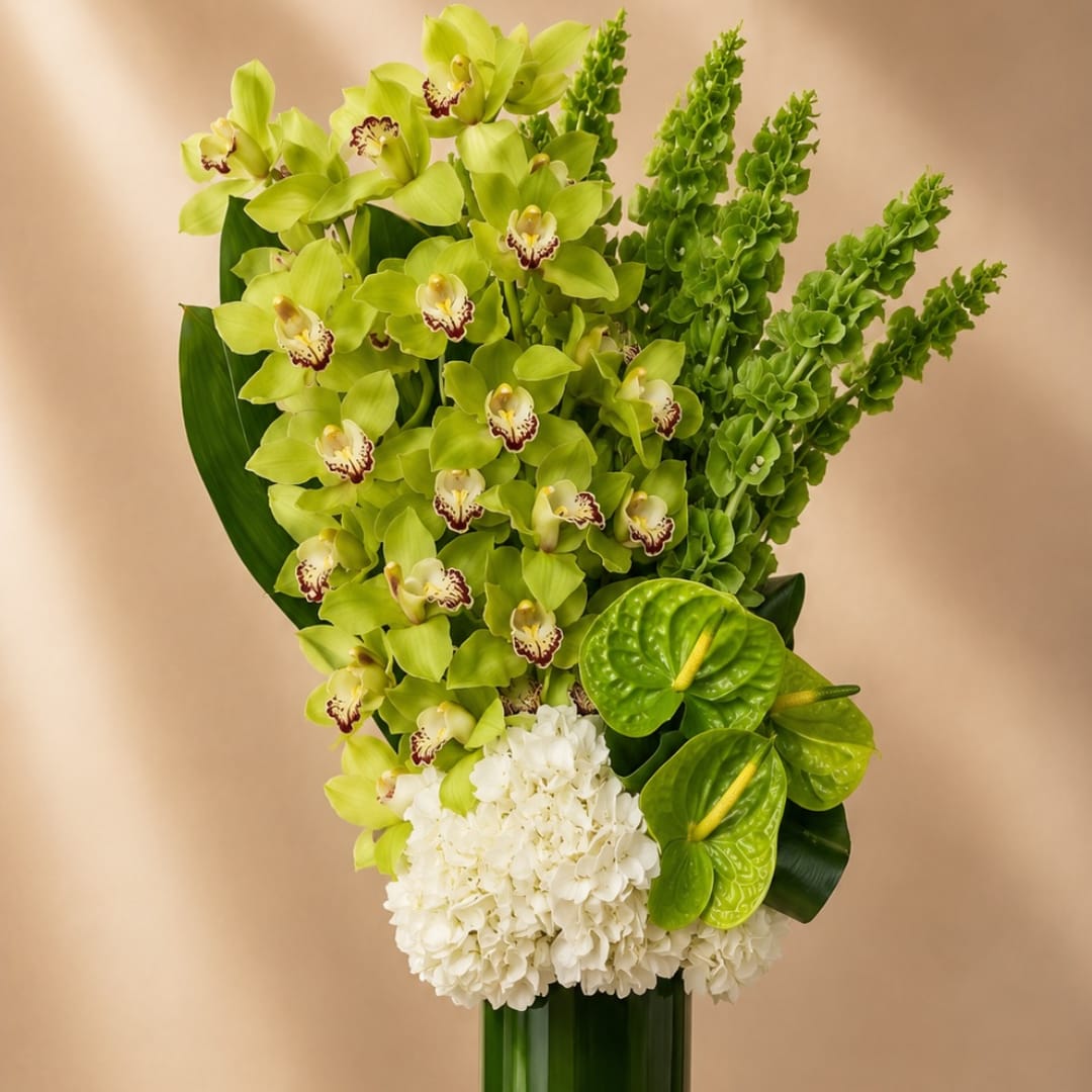Green orchid arrangement with white hydrangea and anthurium in a tall vase